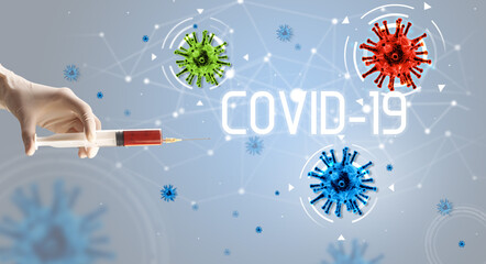 Syringe, medical injection in hand with COVID-19 inscription, coronavirus vaccine concept