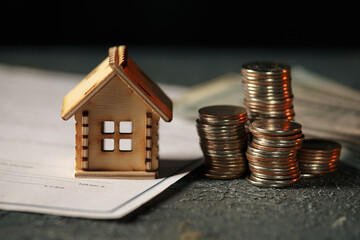 View Of coin stack with house model on green background, savings plans for housing, financial...
