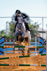 Fototapeta na wymiar Rider jumps over obstacles during horse show jumping