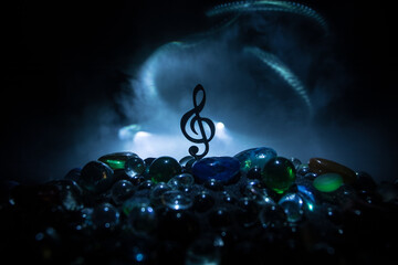 Musical symbol treble clef stainless steel miniature with colorful toned light on foggy background....