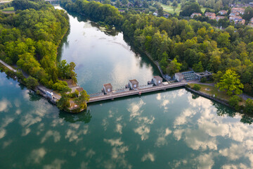 hydroelectric power plant with reflective clouds in the river