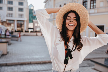 Charming european girl in white blouse expressing happiness in summer day. Outdoor photo of...