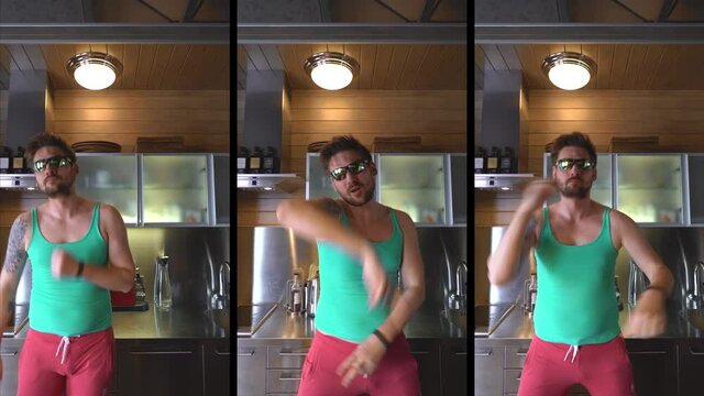 A guy at home on self-isolation fooling around on camera, a freak in the kitchen dancing and grimacing at the camera, a vertical video meme for social networks, a guy in a T-shirt and glasses is funny