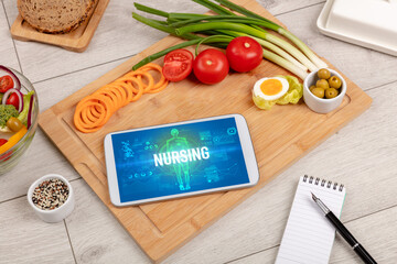 NURSING concept in tablet with fruits, top view