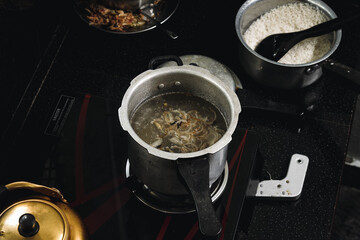 traditional Indian soup preparing in a cocker on a stove.