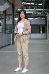 Young Chinese girl standing, smiling and looking at camera