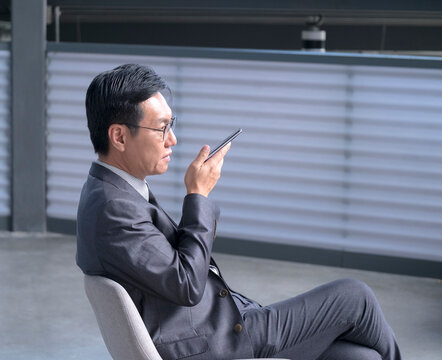 Chinese Businessman Using Cellphone To Leave Voice Message.