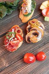 various beautiful bruschettas with vegetables, avocado, salami, cheese, tomatoes, guacamole, olives and radishes on the