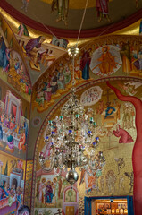 Fototapeta na wymiar The large decoratively decorated metal chandelier hangs in the main hall of the Church of the Apostles not far from Tiberias city in northern Israel