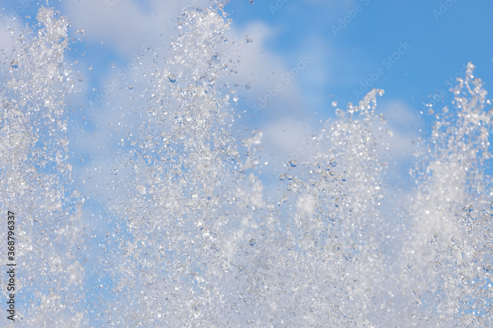 Poster jets with splashing water on the background of the sky with clouds