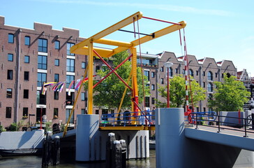 Amsterdam, view on the Nijlpaardenbrug (a drawbridge for bicycle and foot traffic from 1987) and the Entrepotdok (Warehouse Dock), a canal, street and row of former warehouses with the same name.