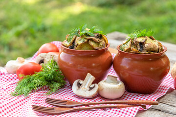 Potatoes with beef and mushrooms baked in a clay pot in the oven.