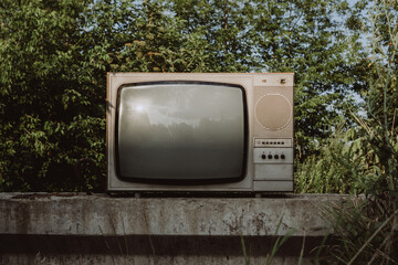 Old retro TV set among nature