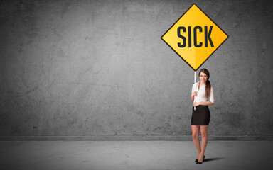 Young business person holding road sign with SICK inscription, new rules concept
