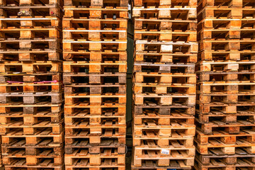A lot stacks of used  wooden pallets of euro type on warehouse is ready for recycling. Industrial background. Close-up. - 368798940
