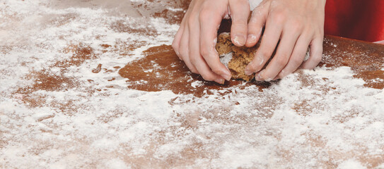 Childrens hands roll out dough for gingerbread. Hands close-up.