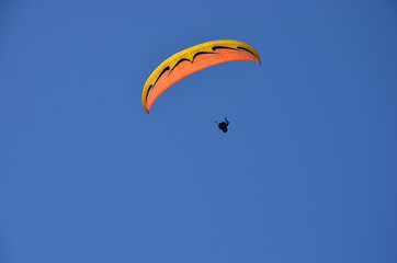 Paraglider pilot in Talloires-Montmin area near Annecy in Upper Savoy (Haute Savoie), France, blue sky background with clouds, a sunny day in summer