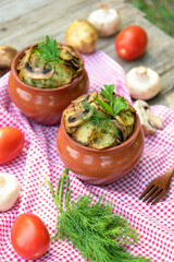 Baked potatoes with mushrooms and meat in a clay pot.