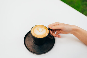 Woman's hand holding a cup of coffee close-up