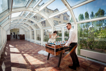 Fototapeta premium the newlyweds play table football together