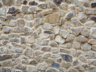 Mosaic pattern of stones, cement. Stone wall. Texture of grey granite. Uneven rock surface of...