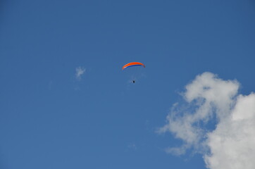 Paraglider pilots in Talloires-Montmin area near Annecy in Upper Savoy (Haute Savoie), France, blue sky background with clouds, a sunny day in summer