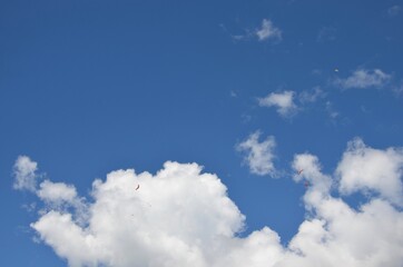 Paraglider pilots in Talloires-Montmin area near Annecy in Upper Savoy (Haute Savoie), France, blue sky background with clouds, a sunny day in summer