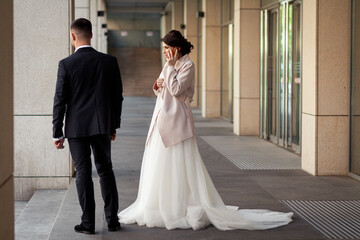 
the bride is talking on the phone in the street