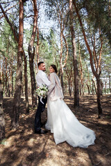 the bride and groom are walking in the woods