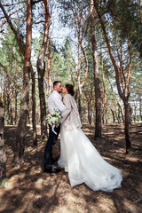 the bride and groom are walking in the woods