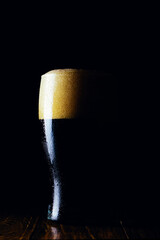 Porter beer mug with foam on a dark background