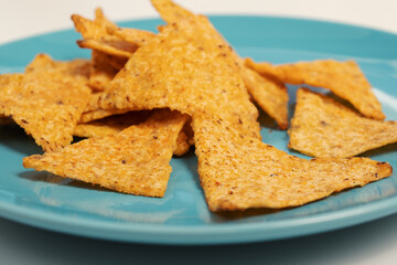 Snacks for the party. Delicious Mexican Nachos Corn Chips on a Blue Plate