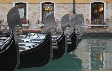 Fototapeta na wymiar series of resting gondolas with windows of a Venetian palace in the background
