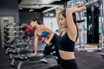 Fototapeta na wymiar Asian woman exercise and lifestyle at fitness gym. Sporty woman workout with trainer and dumbbell weight. Wellness and healthy for bodybuilding.