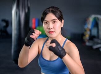 Fototapeta na wymiar Asian woman exercise and lifestyle at fitness gym. Sporty woman workout and boxing with trainer. Wellness and healthy for bodybuilding.