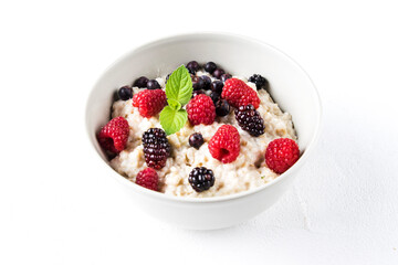 Oatmeal porridge with raspberries and blackberries in a light plate