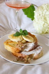 Fried toast with bananas in bed and a glass of wine