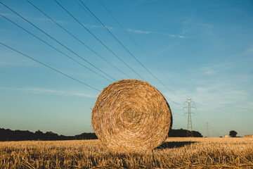 rolled haystack and high-voltage power line in the field