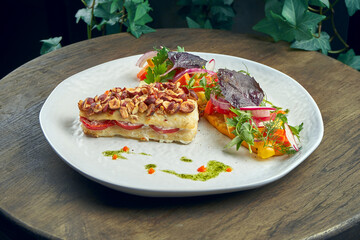 Baked pike perch fillet with peanuts and vegetable salad garnish in a white plate. Seafood