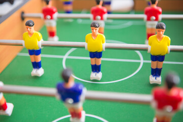 Table football game with yellow and red players and white goalkeeper.