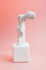 Greek goddess of victory sculpture on pink background