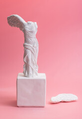 Greek goddess of victory sculpture on pink background - obrazy, fototapety, plakaty