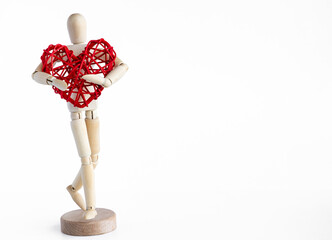 Wooden mannequin holding rattan red heart. White background. 