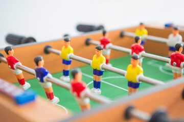 Table football game with yellow and red players and white goalkeeper.
