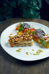 Baked pike perch fillet with peanuts and vegetable salad garnish in a white plate. Seafood