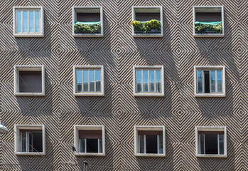 face of cement apartment building with 12 symmetrical windows © David