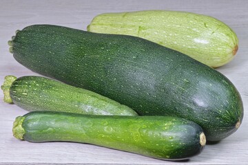 a group of cut fresh zucchini in the skin on a light table