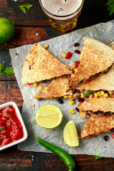 vegetarian black beans tomato corn quesadilla served with cold beer salsa and yogurt dip sause on dark wooden background