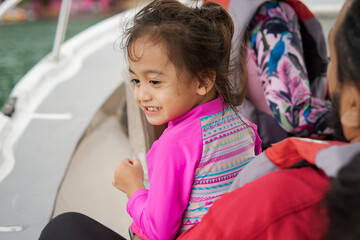 Happy toddler on a boat with family. Vacation, travel and active kid concept.