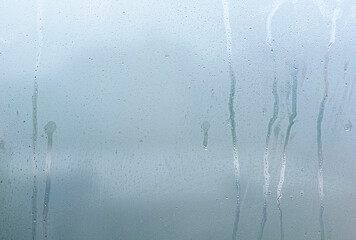 Window with steam condensation and drops after rain, wet glass as background or texture